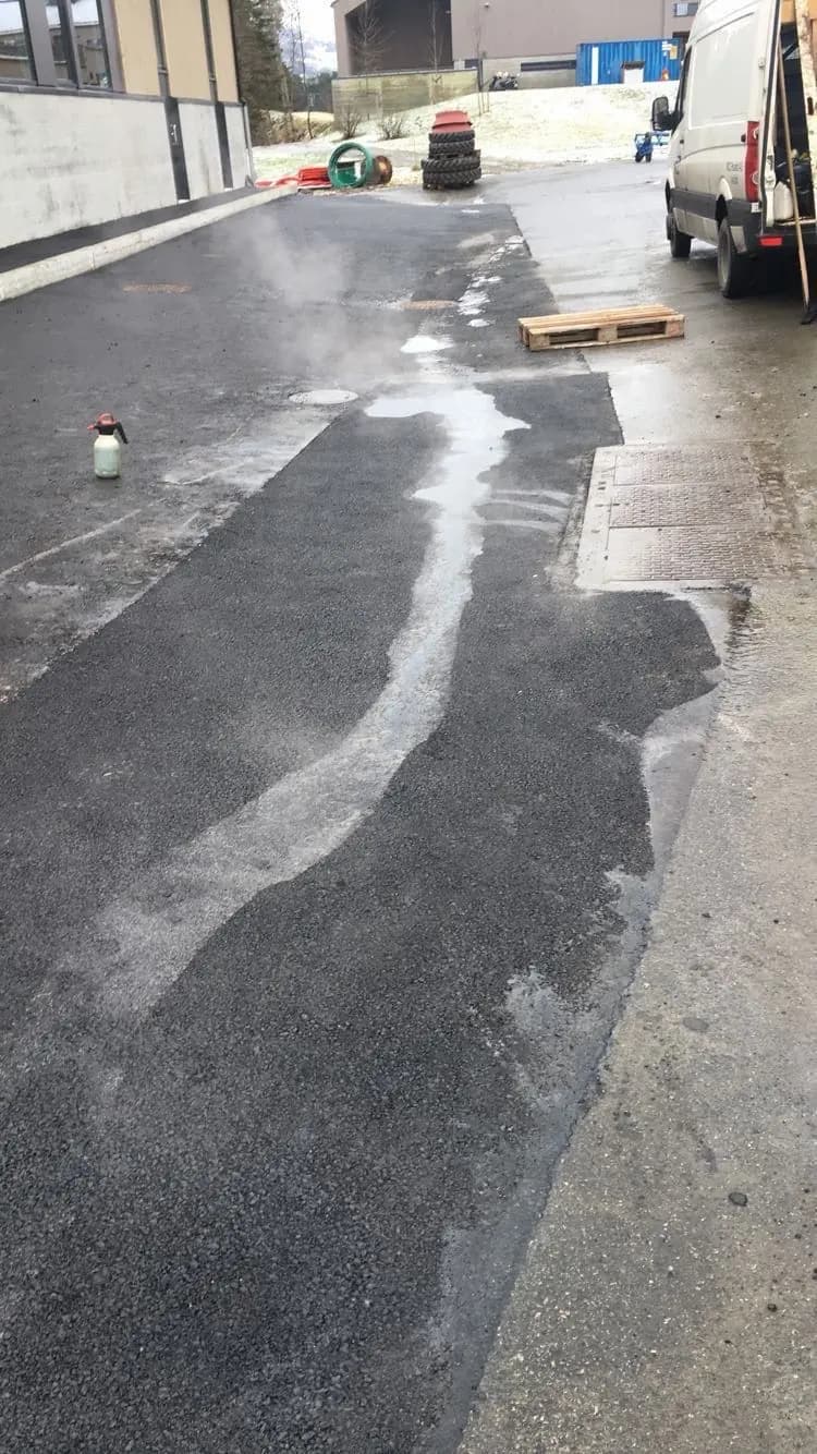 Asfaltarbeid under utførelse: utlegging av varm asfalt på uteområde